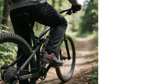 Chaussures de cyclisme avec pédales automatiques fixées sur les pédales d'un vélo de montagne sur un sentier forestier.