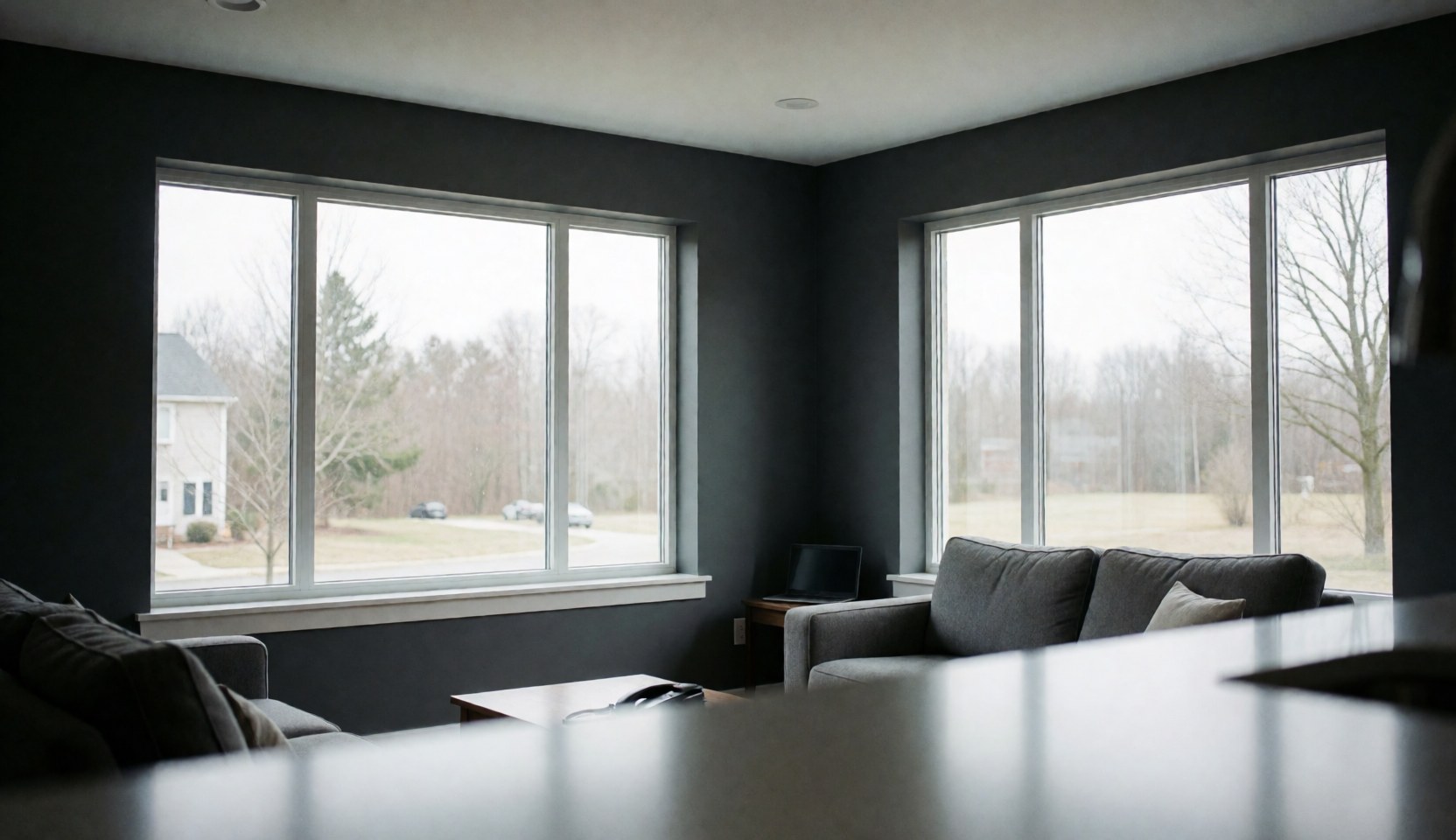 Intérieur de salon moderne aux murs gris avec de grandes fenêtres Low-E laissant entrer la lumière naturelle, espace vide pour texte, idéal pour entreprise d'installation