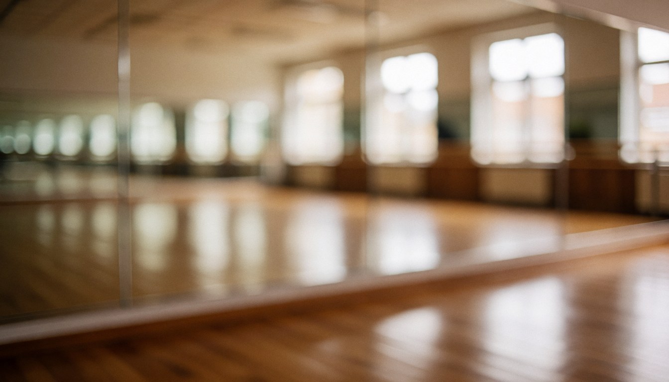Fond de studio de gymnastique avec grands miroirs, sol en bois et fenêtres, idéal pour du texte sur les cours de gymnastique.