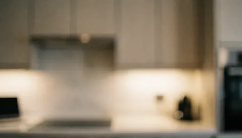 Arrière-plan de cuisine moderne avec éclairage chaleureux, armoires et électroménager, idéal pour des textes promotionnels liés à l'installation de cuisines.