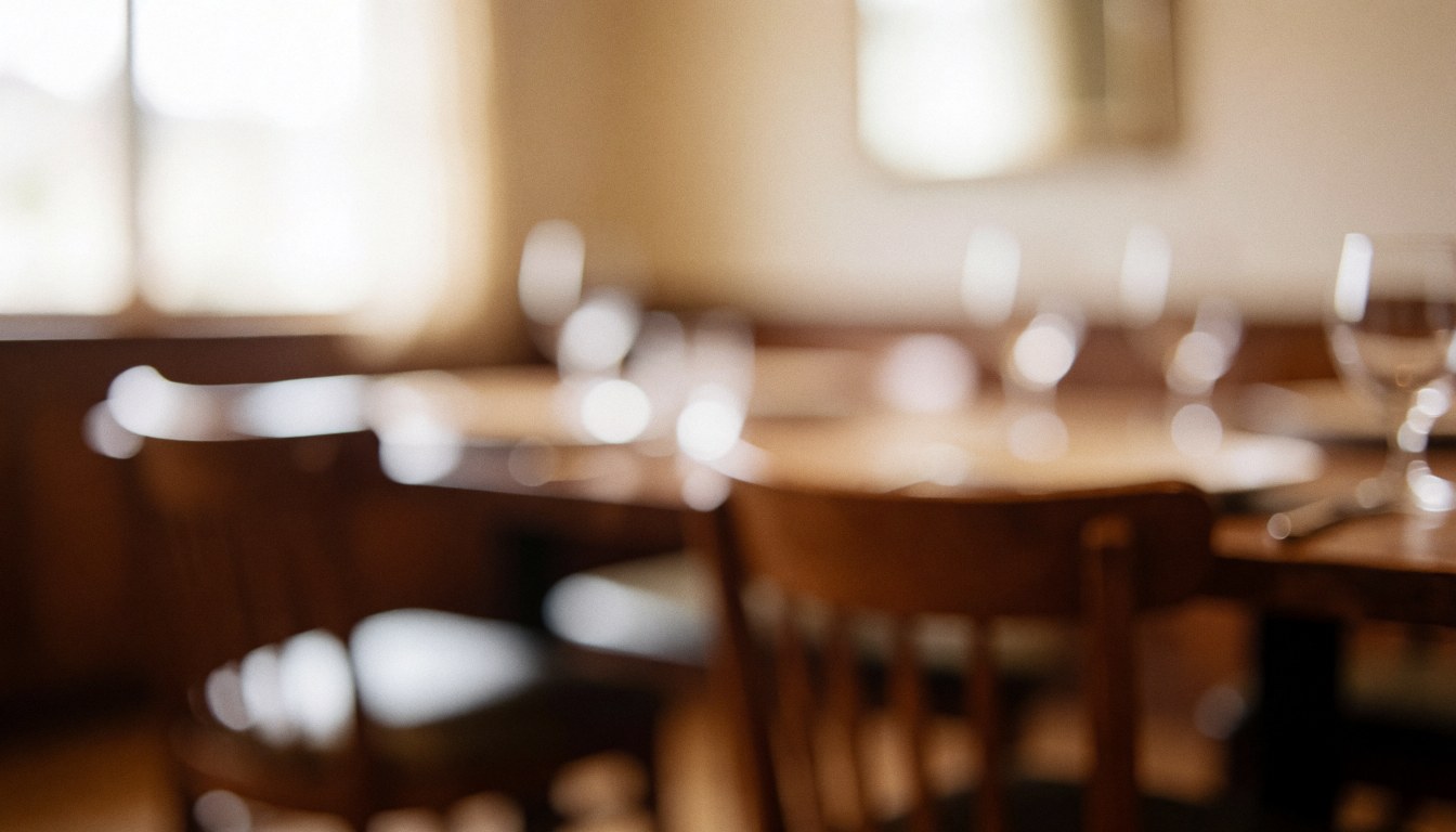 Arrière-plan chaleureux de salle à manger avec tables en bois et chaises floues, idéal pour les textes d'une maison d'hôtes
