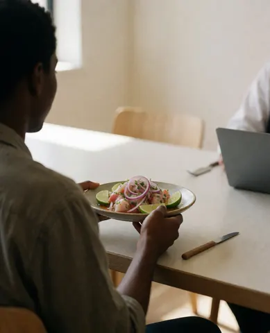 Une cliente profite d'un plat de ceviche dans un restaurant aux murs clairs et à la lumière naturelle, évoquant une ambiance décontractée.