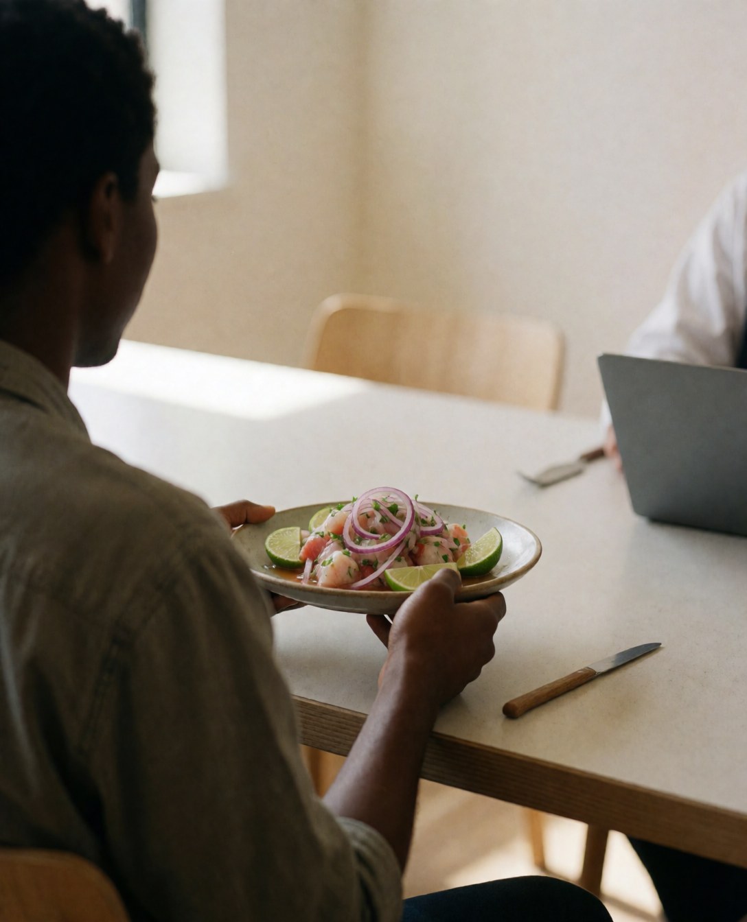 Une cliente profite d'un plat de ceviche dans un restaurant aux murs clairs et à la lumière naturelle, évoquant une ambiance décontractée.