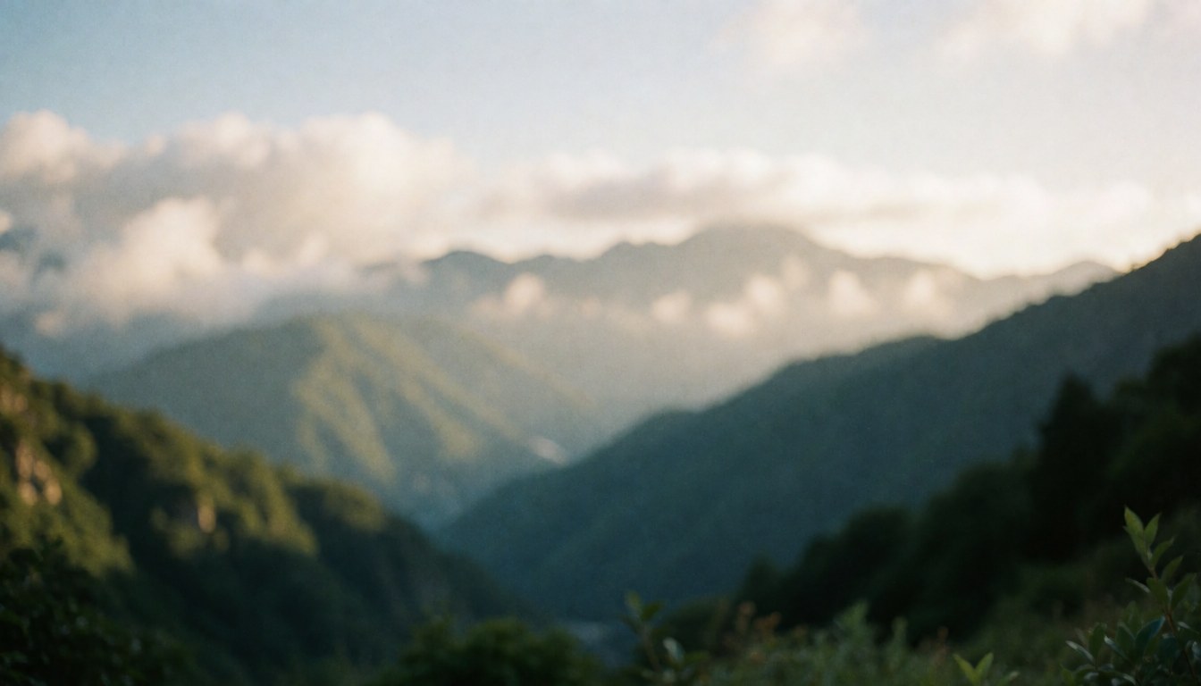 Paysage de montagnes avec des nuages et une lumière chaude, idéal pour un arrière-plan de texte concernant un entraîneur de vélo de montagne.