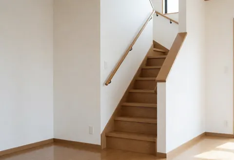 Escalier en bois avec rampe, murs blancs et sol en bois, idéal pour un installateur d'escaliers dans un intérieur résidentiel moderne.