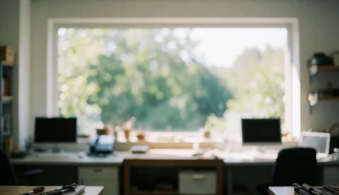 Fond de bureau avec lumière naturelle, fenêtres à végétation floue, tables et chaises, idéal pour du texte sur l'écriture.