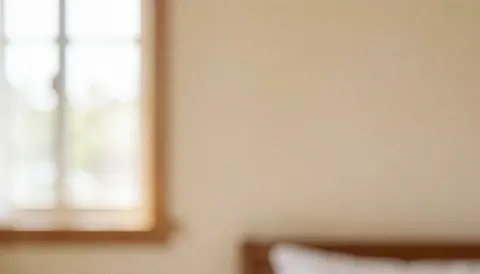 Fond de mur de chambre avec cadre de fenêtre et tête de lit, éclairage doux et tons chauds pour textes
