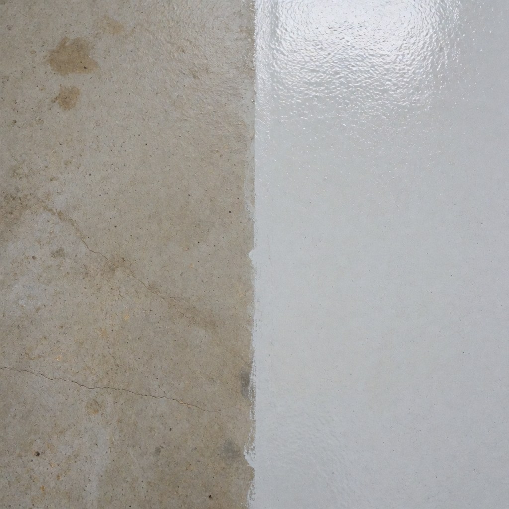 Détail d'un mur en béton montrant une zone sale à côté d'une zone propre, illustrant le résultat d'un service de nettoyage industriel professionnel.