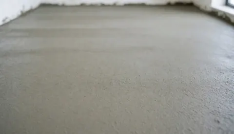 Surface de béton nouvellement coulée et lisse, servant de fond neutre et épuré pour des textes promotionnels liés à l'installation de courts de tennis.