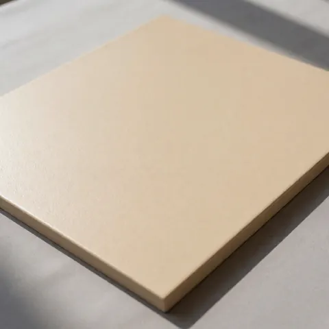 Panneau d'enduit synthétique beige à texture uniforme sur fond gris neutre, idéal pour des finitions extérieures modernes.