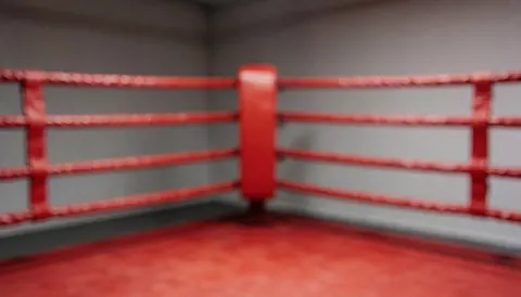 Ring de boxe avec cordes rouges et poteaux, murs neutres et sol rouge, idéal pour textes de formation.