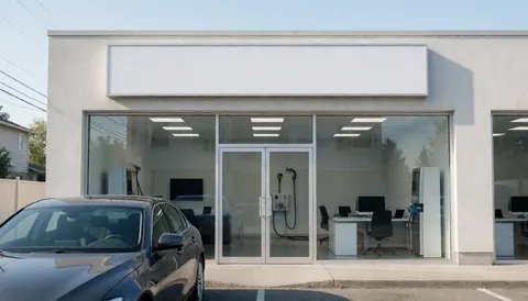Façade d'un lavage de voitures avec un véhicule stationné devant l'entrée, murs propres et un espace ample pour le texte.
