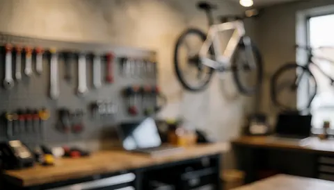 Arrière-plan d'atelier de vélos avec bicyclettes suspendues et outils en support, éclairage chaleureux et murs neutres